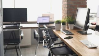 Computer monitors standing on table in empty office